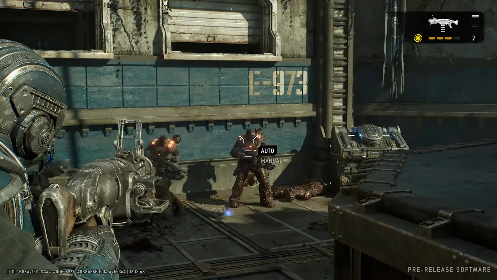 First-person Gut-Puncher aim at Locust drones beside a blue shipping container wall with the AUTO and MANUAL detonation mode tags stacked over the target